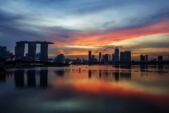The Singapore skyline at sunset, reflected in still water